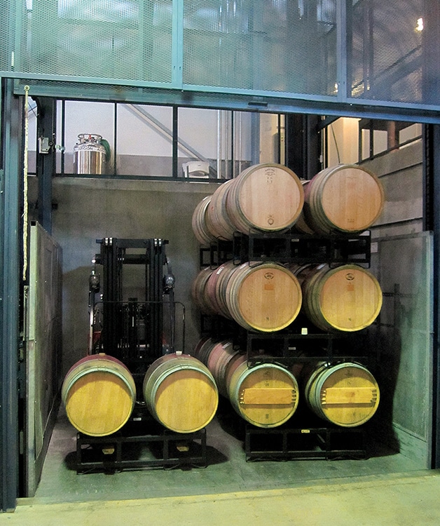 A forklift loaded with barrels aboard the purpose-built PFlow vertical reciprocating conveyor at Joseph Phelps Vineyards’s unique underground winery.